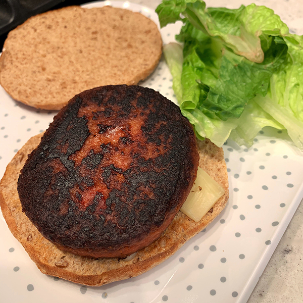 Trader Joe's Protein Patty on a multigrain bun on a white polka dot plate with lettuce