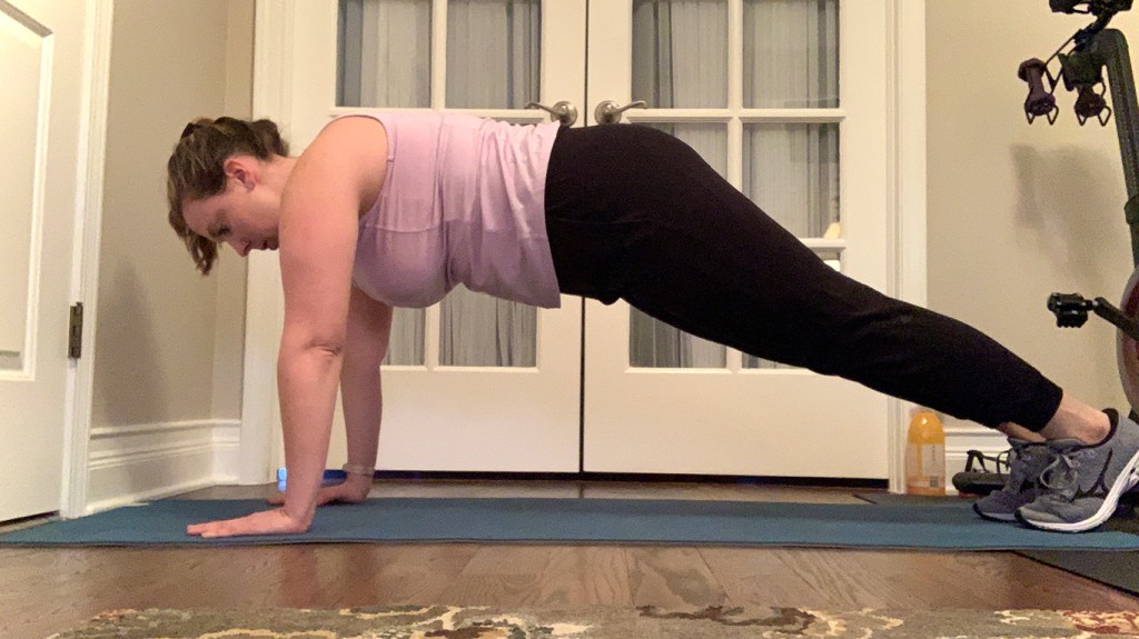 Female doing a plank exercise on a blue yoga mat